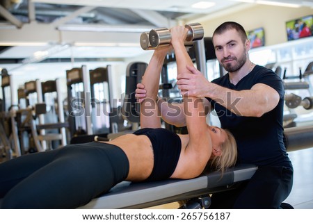 Intensive training together. Couple of young and beautiful people is having workout in a gym. Perfect shape. Sportsmen. Hard workout in a gym. Athlete people