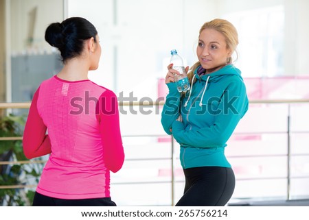 Intensive female training together. Couple of young and beautiful women are having workout in a gym. Perfect shape. Sportsmen. Good workout in a gym. Communication and sport