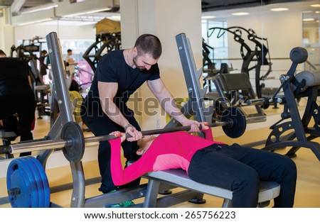 Intensive training together. Couple of young and beautiful people is having workout in a gym. Perfect shape. Sportsmen. Hard workout in a gym