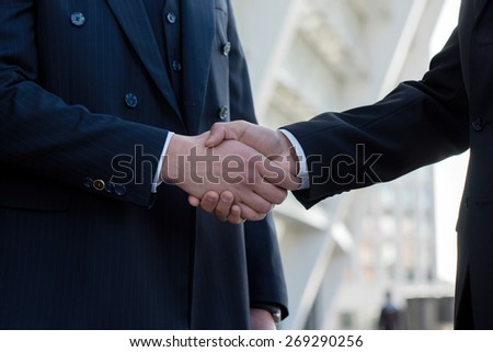 Good deal. Two confident businessmen are shaking hands after successful deal. Business concept