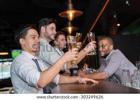 Beer evening in a pub. Male friends are drinking beer in a pub after working day. Beer glasses.  Beer pub concept. Men are waiting for football and beer