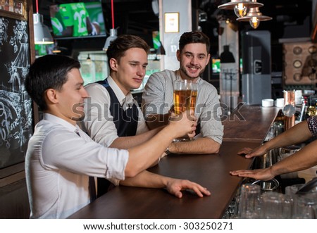 Beer evening in a pub. Male friends are drinking beer in a pub after working day. Beer glasses.  Beer pub concept
