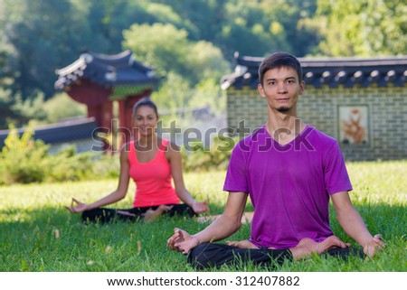 Perfect yoga. Handsome young man is balancing doing yoga. Pair yoga concept. Yoga outdoor class workout Acro-yoga.