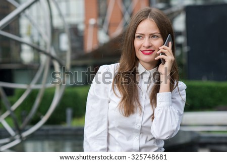 Business confidence. Portrait of motivated business woman. Successful woman on formal wear at work with mobile phone. Outdoors business concept.