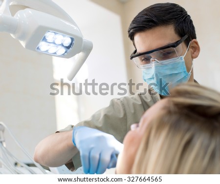 Healthy teeth. Confident professional doctor dentist at work in his medical dental office. Doctor wearing medical clothing.