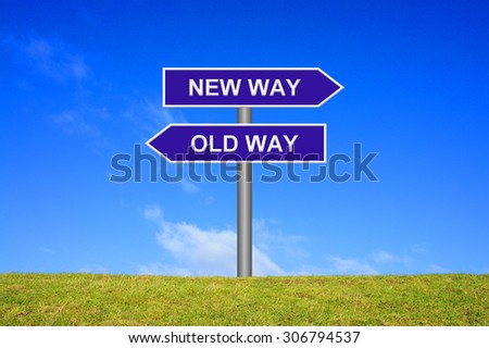 Street Sign showing new way or old way in front of blue sky on green grass