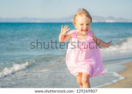 Happy little girl running on the beach