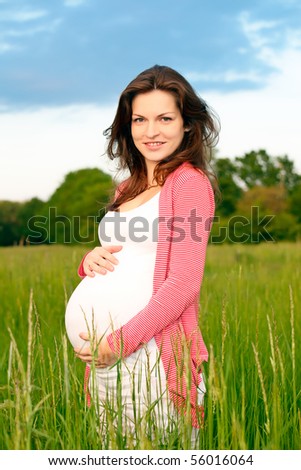 Beautiful pregnant woman on meadow
