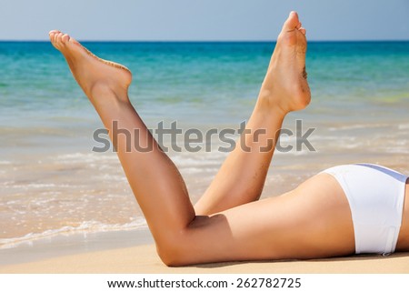Woman\'s beautiful legs on the beach