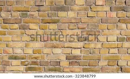 A brick wall, old stones, sand color brick. Textured plaster, sunlight protection. Old city