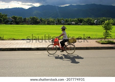 Dien Bien Phu, VIETNAM - July 28, 2014: A person riding a bike on a suburban road