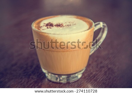 coffee latte cup on a wood table -vintage effect style pictures