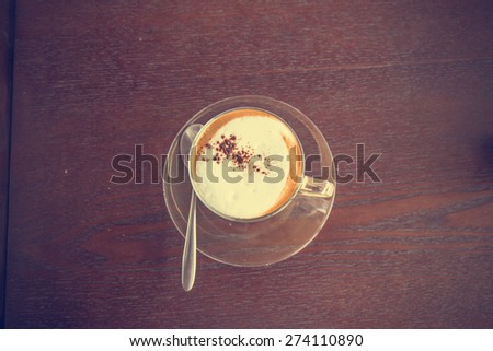 coffee latte cup on a wood table -vintage effect style pictures