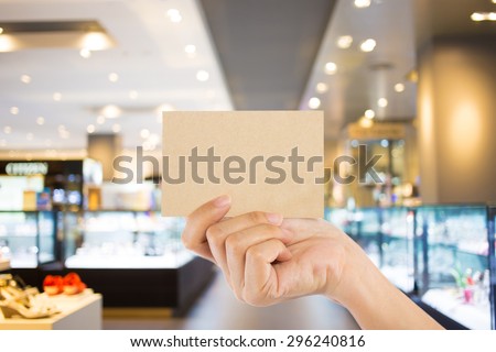 Photo blank. Hand hold blank business card in the shopping mall.