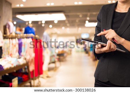 Women in shopping mall using mobile Tablet PC.