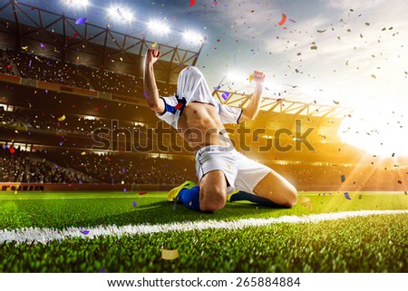 Soccer player in action on night stadium panorama background