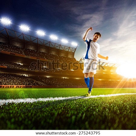Soccer player in action on night stadium panorama background
