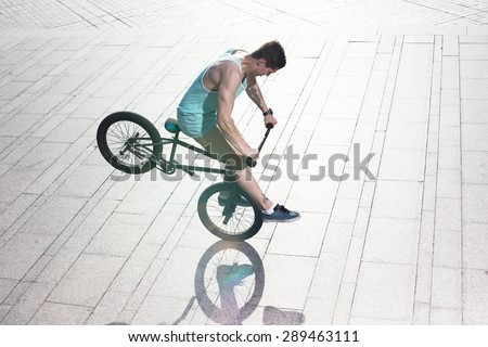 bmx bicycle rider tricking on the highlights