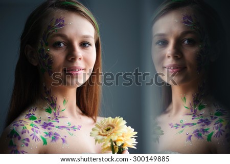 Girl with flower bodyart and sunflowers bouquet and wreath near window