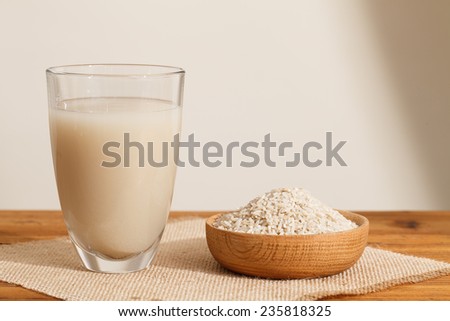 The water that clean out rice like milk in the glass?and Some rough rice in wooden bowl