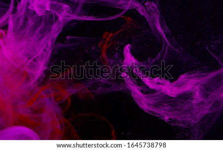 Pink watercolor ink in water on a black background. Colored space magic background. Digital strings matrix. Abstract background. Cool trending screensaver.