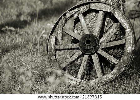 Old broken wheel of the horse cart in sepia