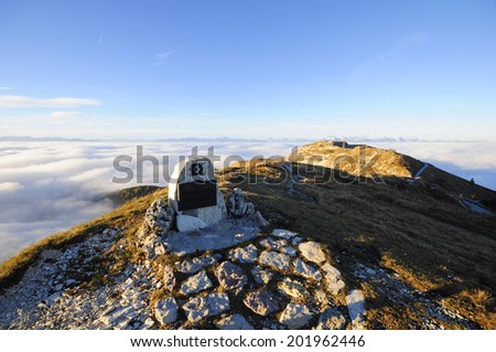 Military memorial on the top of a mountain with light that emerges from clouds