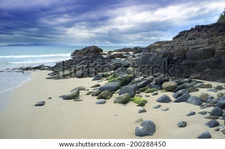 Beautiful landscape beach with rocky shore and dramatic clouds, Noosa Heads, Sunshine Coast, Australia