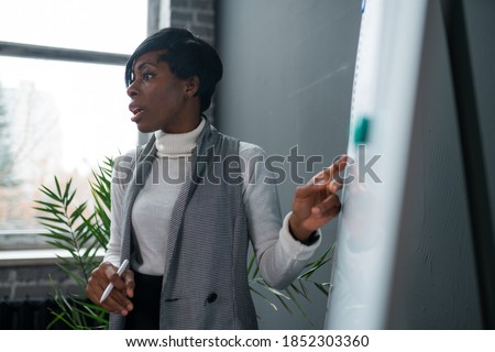 african-american lady business trainer coach leader give flip chart presentation consulting clients teaching employees training team strategy at marketing workshop concept