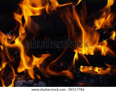 Flames in a fire pit with glowing embers