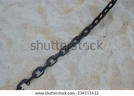 Old rusty metal chain in the sand