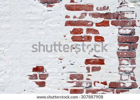 Brick wall with fallen plaster.
