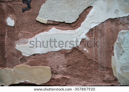 Old grunge wall with fallen red and white plaster.