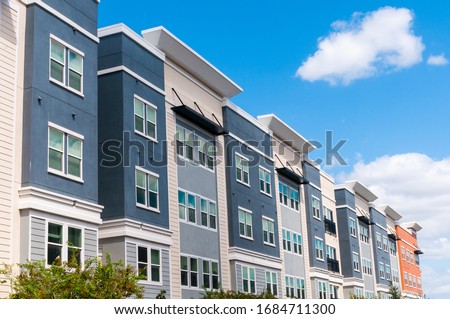 Modern luxury urban apartment building exterior with blue sky.