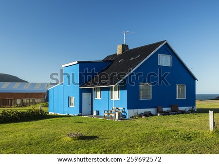 Beautiful blue house against the blue sky in Iceland.