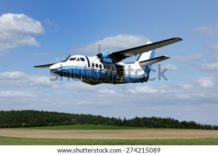 The plane used for parachuting is seen on blue sky. All logos and text removed.