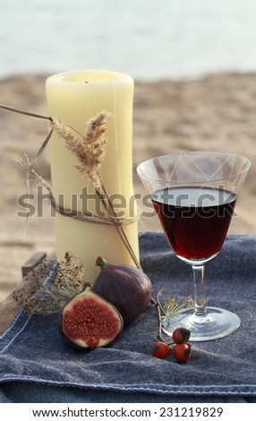 candles and red wine - romantic dinner on the water in Scandinavian style/Candle and red wine on the beach