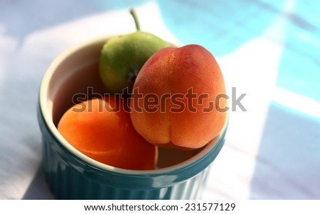 appetizing, juicy peaches in a blue bowl on the table/	appetizing, juicy peaches in a blue bowl