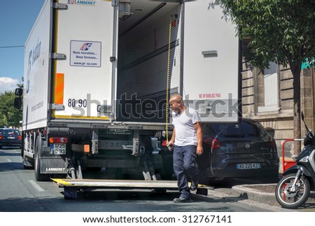 BORDEAUX, FRANCE, SEP 03, 2015 : Male mover opening the door of his moving van on the street.