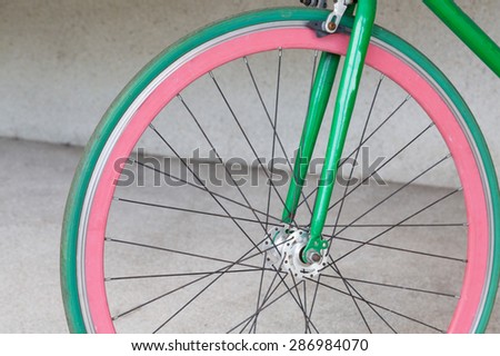 wheel of green fixed gear bicycle at building
