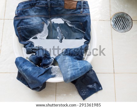 Jeans in water bucket on washing area