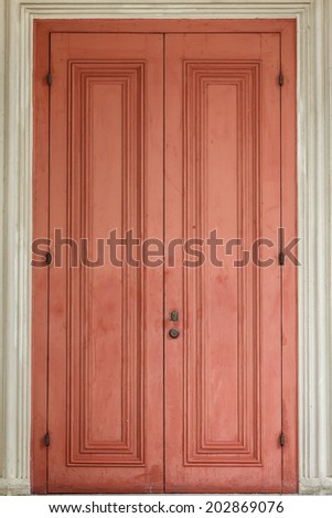 Ancient red door with white door frame.
