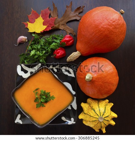 Pumpkin soup or squash soup with parsley and paprika against white background