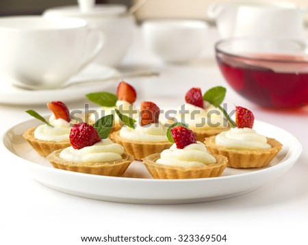 Many cakes, cupcakes with fresh fruits, whipped cream, jelly and mints