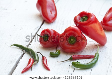 Variety of fresh peppers on white wood table