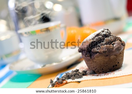 A tasty chocolate muffin at breakfast isolated on color background. Muffin on focus and shallow depth of field