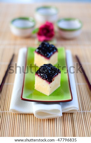 Japanese cheesecake treats served on an asian plate with chop sticks. Shallow depth of field on the first cheesecake treat.