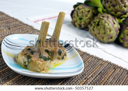 a plate with a couple of artichokes hearts cooked \