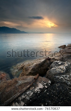 the Italian gulf of Gaeta under the morning light with cloudy sky and the sun shining through.
