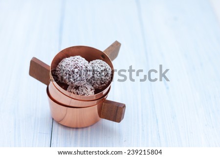 candy oatmeal, chocolate, nuts and coconut in copper cups on a blue wooden background